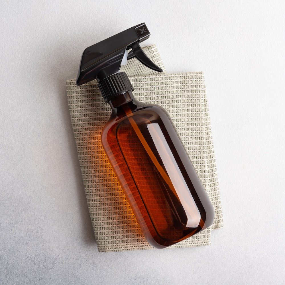 Single amber brown spray bottle on a cloth. Home made cleaning products for eco friendly and sustainable life style.